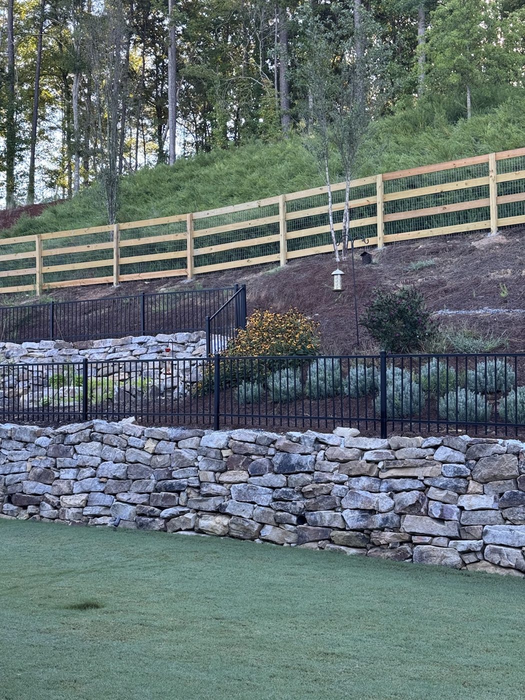 Rail fence above a stone retaining wall